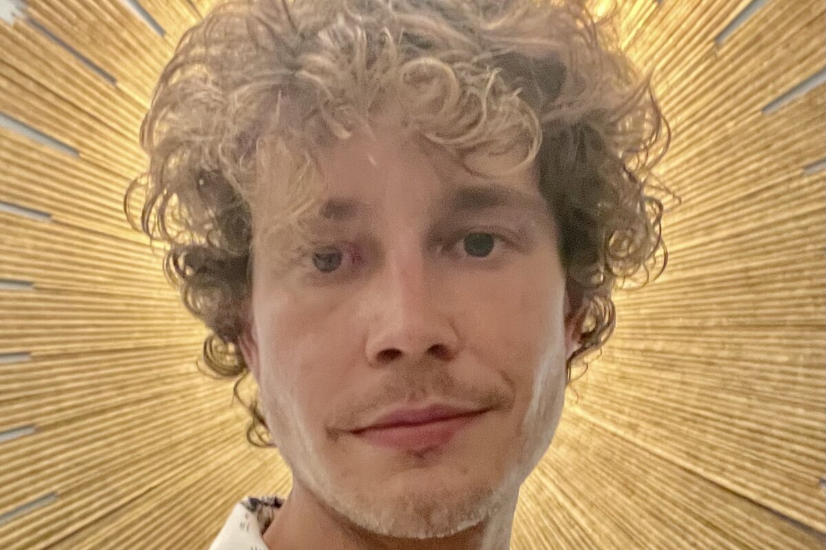 Austin Martin, LNC Region 1 Representative, in front of a gold sunburst